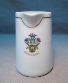 a white vase with a gold trim around the bottom