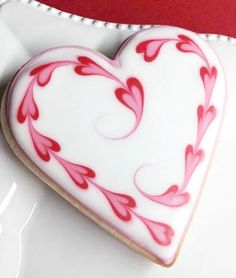 a heart shaped cookie sitting on top of a white plate