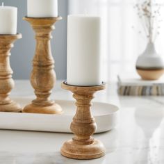 three white candles are sitting on a table