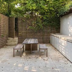 a wooden table and bench sitting in the middle of a yard