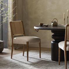 a dining room table with two chairs and a tea pot on top of the table