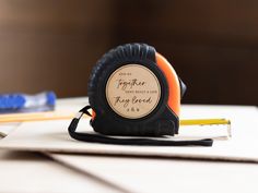 a tape measure sitting on top of a table next to some pencils and an eraser