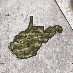 a sticker with the shape of a map in camouflage on it next to a ruler