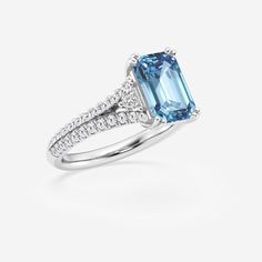 an aqua blue and white diamond ring on a white background with diamonds around the band