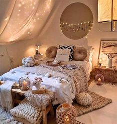 a bed with pillows and blankets in a room that has lights on the ceiling above it