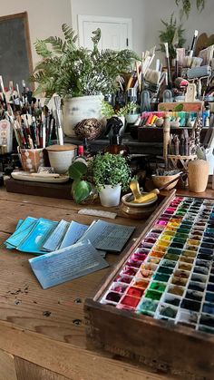 a wooden table topped with lots of art supplies