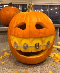 two pumpkins that have teeth and braces on them