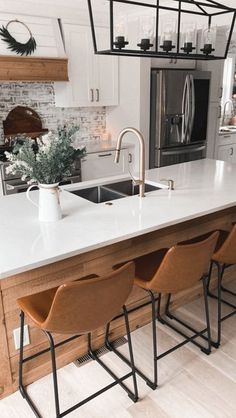 a kitchen with white counter tops and wooden stools in front of the bar area