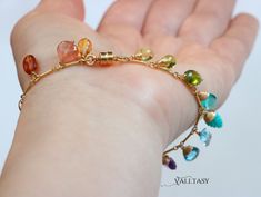 Amazing vibrant colors in this unique gemstone bracelet! The fancy shape gemstones dangle and dance on your wrist creating a never-ending play of color and glow! Each gemstone briolette as unique and special as YOU! This bracelet is full of movement and creates an attractive boho chic modern look. You can wear it separately or [...] Elegant Rainbow Colored Bangle Jewelry, Multicolor Gold Bracelet With Gemstones, Multicolor Fusion Bracelet With Natural Stones, Elegant Multicolor Charm Bangle Bracelet, Elegant Multicolor Gemstone Bracelets, Fusion Style Multicolor Natural Stone Bracelets, Fusion Style Multicolor Natural Stones Bracelet, Multi-stone Fusion Bracelet, Elegant Multicolor Charm Bracelet As Gift