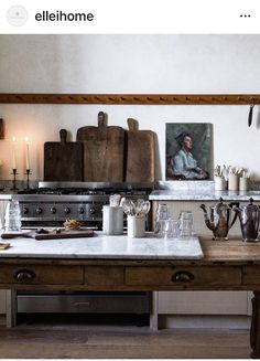 an old fashioned kitchen with many items on the counter and in front of it is a painting