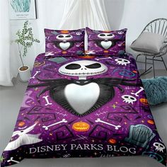 a bed with a purple comforter and two pillows