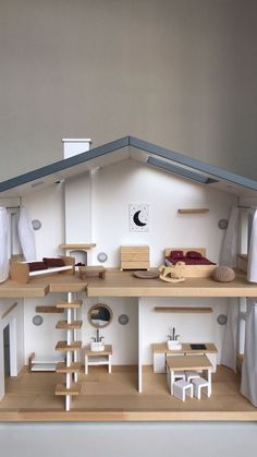 a doll house with furniture and accessories on the shelves in front of it's roof