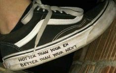 someone wearing black and white shoes with writing on the side of their shoe, which reads, hotter than your next better than your next