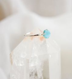 This petite yet dazzling ring, made of sterling silver, displays a beautiful slice of genuine Larimar. Regardless of your personal style, every gem boasts their own individual shape, making them just as exceptional as you. Each stone ranges in a mix of aqua blue and white. Larimar Meaning: Exclusive to the Dominican Republic, Larimar is a rare blue form of Pectolite. The man who coined the name Larimar, named it after his daughter, taking part of her name (Larissa) and the Spanish word for sea ( Turquoise Larimar Ring As Gift, Turquoise Larimar Ring For Gift, Larimar Turquoise Ring Gemstone Gift, Turquoise Larimar Ring Gift, Larimar Turquoise Ring Gift, Blue Larimar Opal Ring, Gift Turquoise Larimar Ring, Blue Sterling Silver Jewelry With Raw Stone, Turquoise Crystal Gemstone Ring In Sterling Silver