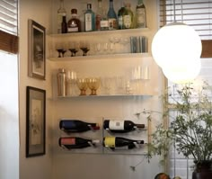 there are many bottles and glasses on the shelves