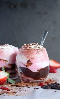 two desserts with strawberries and chocolate on the side