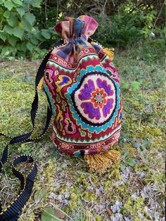 "Medium Drawstring Silk Petit Point Handbag created and handmade in Uzbekistan. Trimmed and Lined with silk and cotton ikat fabric, hand woven silk strap with tassels and a drawstring closure. Each handbag is hand drawn onto cotton canvas, inspired by original designs from Uzbekistan textile history.  8\" high x 8.5\" width (17\" in diameter), top opening 17\" wide, approx. 54\" strap x 1/2\" width. Drawstring goes through ikat channel and closes with tassels at the end of the drawstring. Can fi Artisan Handmade Bags With Multicolor Embroidery, Traditional Ceremonial Pouch Bag, Bohemian Multicolor Potli Bag Pouch, Traditional Rectangular Potli Bag With Multicolor Embroidery, Traditional Bags With Multicolor Embroidery And Handwork, Handmade Multicolor Embroidered Potli Bag For Festivals, Traditional Multicolor Pouch Shoulder Bag, Handmade Tapestry Bag For Gift, Artisan Multicolor Embroidery Bag For Festivals