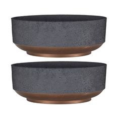 two grey concrete bowls with copper rims