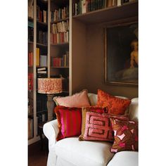 a living room filled with lots of furniture and bookshelves full of books on top of them