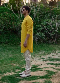 The dholpur kurta in mustard is a sophisticated choice for Indian grooms, perfect for haldi, mehndi, or sangeet ceremonies. Crafted from a blend of viscose cotton silk and georgette, this kurta offers a smooth and breathable feel, ensuring comfort during festive occasions. The kurta comes with an ivory churidaar, creating a balanced and harmonious ensemble. The dholpur kurta is ideal for grooms seeking a classic yet contemporary outfit. Pair it with traditional juttis or modern footwear for a polished and sophisticated appearance. Indian Groom, Bespoke Tailoring, Contemporary Outfits, Churidar, Cotton Silk, Mustard, Festival, Silk