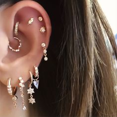 a woman wearing ear piercings with stars and pearls