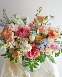 a vase filled with lots of different colored flowers