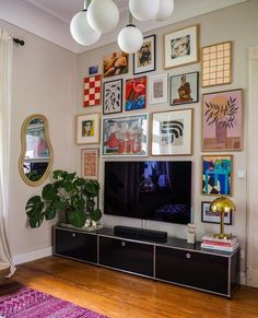 a living room with pictures on the wall and a large flat screen tv mounted to the wall