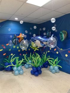 an ocean scene with fish, bubbles and seaweed in front of a blue wall