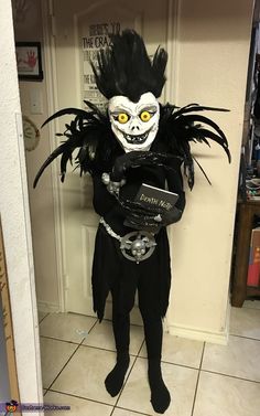 a man dressed as a skeleton holding a skateboard in front of a door with words written on it