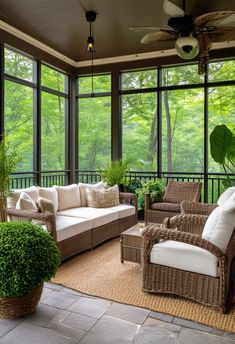 a screened porch with wicker furniture and large windows overlooking the trees in the background