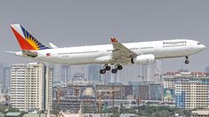 an airplane is taking off from the runway in front of some buildings and skyscrapers