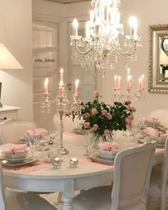 a dining room table set with pink napkins and place settings