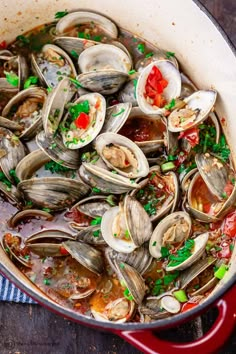 a pot filled with clams and sauce on top of a table