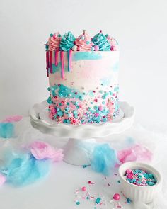 a birthday cake with sprinkles and blue frosting on it, surrounded by confetti