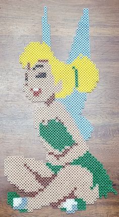 an image of a woman sitting on the floor in front of a cross stitch pattern