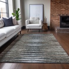 a living room with two white couches and a rug in front of a fireplace