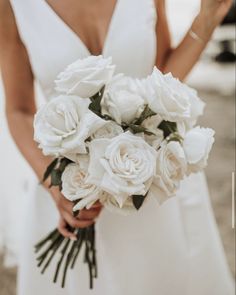 a woman holding a bouquet of white flowers