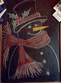 a chalk drawing of a snowman wearing a hat and scarf with holly berries on it