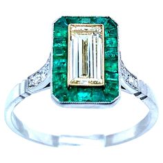 Platinum ring with one baguette cut diamond that weighs 0.71 carat, 6 old mine cut diamonds that weigh 0.09 carat, and 22 emeralds that weigh 0.55 carat. An art deco recreation, this ring weighs 3.6 grams. Size 7.25. Diamond Emerald Ring, Baguette Cut Diamond, Platinum Ring, Baguette Cut, Emerald Ring, Solitaire Ring, Diamond Cuts, Platinum, Emerald