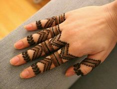 a woman's hand with henna tattoos on it