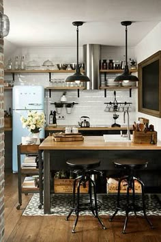 a kitchen with an island and stools in the center, surrounded by brick walls