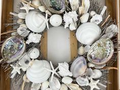 a wreath made out of seashells and sea urns is displayed in a box