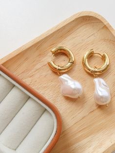 Unleash your inner risk-taker with Bubbles Gold Statement Large Pearl Earring! These modern mermaid earrings feature bold bubbles that add a daring touch to any outfit. Make a statement and conquer the sea with these unique and stylish earrings. 🧜‍♀️🌊 18K Gold Non-Tarnish Large Huggie Droplet Earring Stainless Steel 18K Gold Plated Measurement, Baroque Pearls (L x W inch): 1 x 0.6 Trendy Pearl Charm Earrings For Party, Trendy Single Hoop Pearl Earring, Trendy Pearl Earrings With Pearl Charm For Party, Trendy Party Pearl Earrings With Charm, Trendy Hoop Pearl Earrings, Trendy Single Pearl Earring For Party, Trendy Pearl Charm Drop Earrings, Modern Mermaid, Shell Jewellery