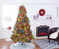 a brightly colored christmas tree in a living room with a fireplace and wreath on the wall