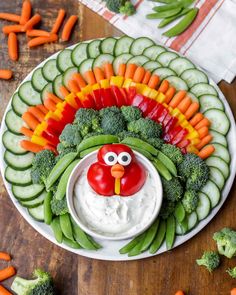 a platter with vegetables, veggies and a face painted in the shape of a turkey