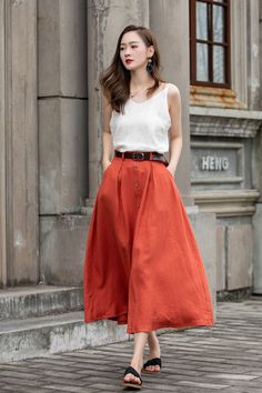 "DETAIL * 100% Linen * Two side pockets * Back elastic waist * Button down skirt * Button front skirt * Below Knee Length * A Line skirt, Midi skirt * Perfect for Spring, Summer and Autumn * Wash by hand or machine with cold water * Model's belt is not sale item * The model is 170 cm (5′ 7″) tall with a 80 cm (31.5\") bust, 66 cm (26\") waist. She is wearing in size XS. CUSTOM MADE SERVICE If you * Change other color * Can't find your size in our size Chart * Change the Style * Change the length Casual Flared Maxi Skirt With Button Closure, Summer Midi Skirt With Button Closure, Relaxed Midi Skirt With Buttons, Orange Skirt For Workwear In Summer, Knee-length Summer Skirt With Button Closure, Summer Knee-length Skirt With Button Closure, Flowy Buttoned Maxi Skirt For Summer, Summer Wide Leg Maxi Skirt With Button Closure, Casual Full Skirt With Button Closure