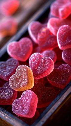 there are many heart shaped candies on the table