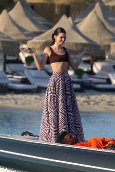 a woman standing on top of a boat next to a man