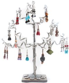 a metal tree with earrings hanging from it's sides and on top of a stand