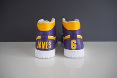 Custom Air Jordan 1 to represent your favourite team or player (Kobe Bryant & LeBron James pairs pictured) - Features player's name and number on Jordan 1 heel tab - Jordan 1, Low or Mid available - You choose your favourite team and/or player - Message me for mockup to finalise design Team-colored Sneakers For Sports With Team Spirit, White Sneakers With Team Name For Sports, Throwback Basketball Shoes For Sports Season, Team Sneakers For Game Day, White Team Spirit Sneakers With Team Name, White Sneakers With Team Spirit, Sporty Customizable Sneakers For Sports, Customizable Sporty Sneakers For Sports, Kobe Bryant Lebron James